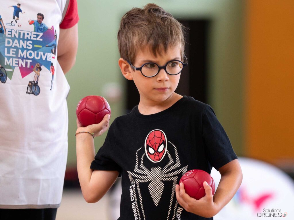 Jeune garçon malvoyant des Handi'Spensables jouant à la boccia